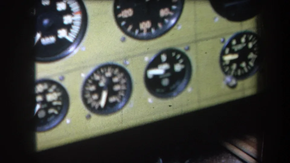 Final close frame of the 1964 cockpit instrument panel, with multiple analog gauges and warm 8mm color.