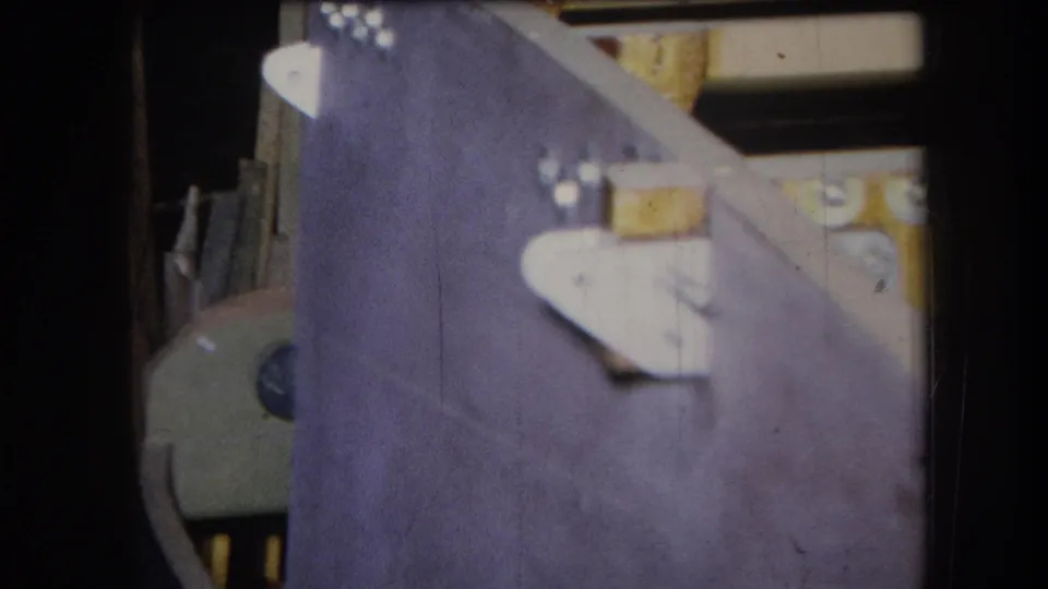 An angled 8mm frame shows the purple-painted panel from the side, with pale bracket shapes, screws, wood, and a partial round object behind it.