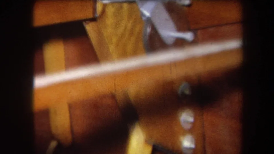 Yucaipa 1964 home-movie frame of wooden rails, varnished boards, silver hinge hardware, and screw heads in warm 8mm color.