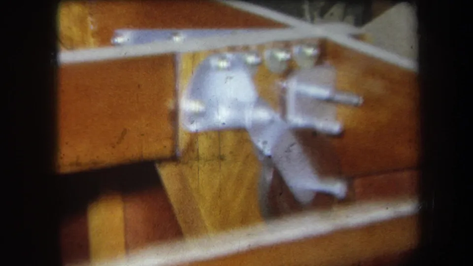 1964 Yucaipa 8mm frame showing a compact wooden mechanical assembly with metal hardware, bolts, and a crossing rail.