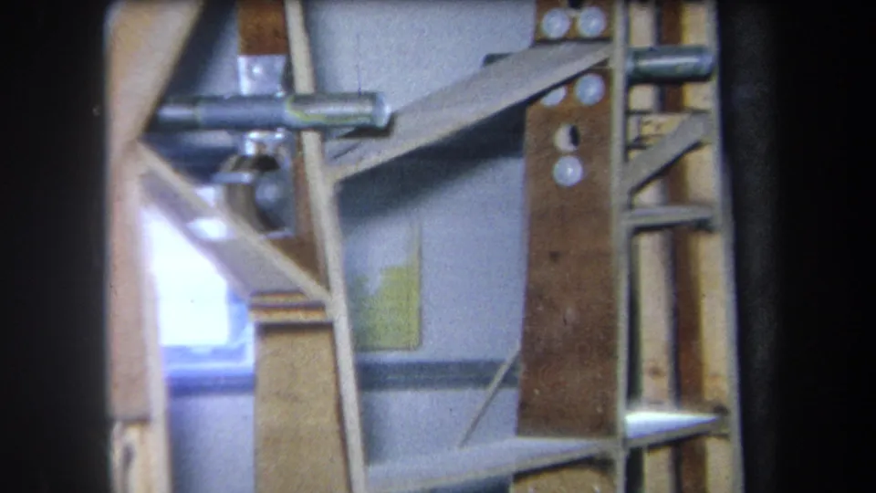 1964 Yucaipa interior frame with wood shelving, metal hardware, a gray wall, and a small bright window or opening.
