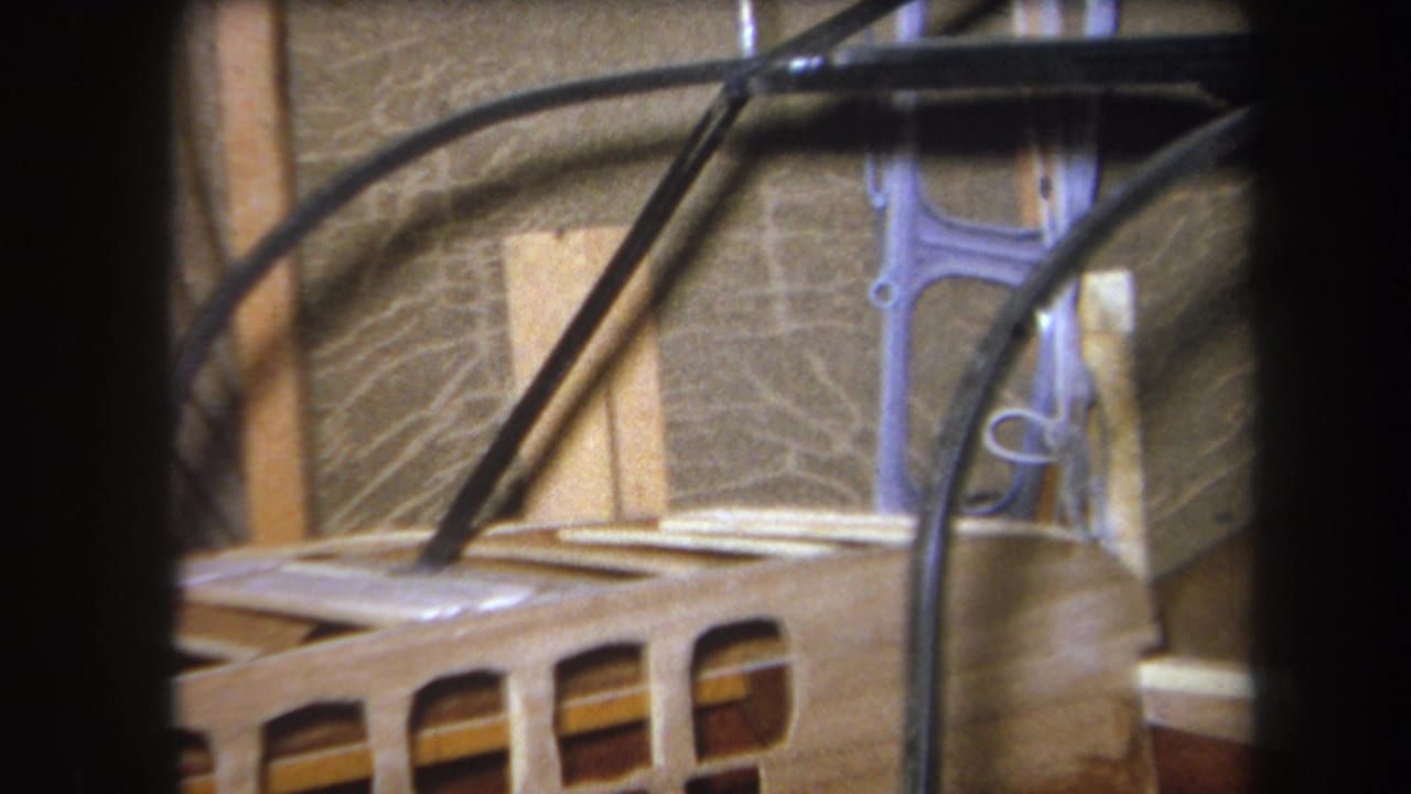 Cables run over a wooden structure with slats and wall material behind.