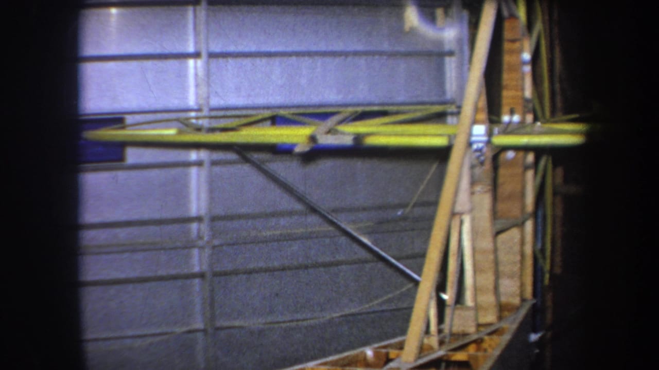 Gray wall panels with yellow metal bracing and diagonal wooden supports.