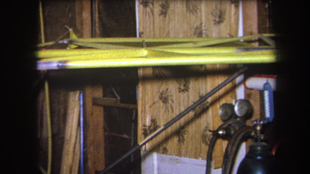 Yellow beam and workshop wall seen behind a green cylinder with two round gauges.
