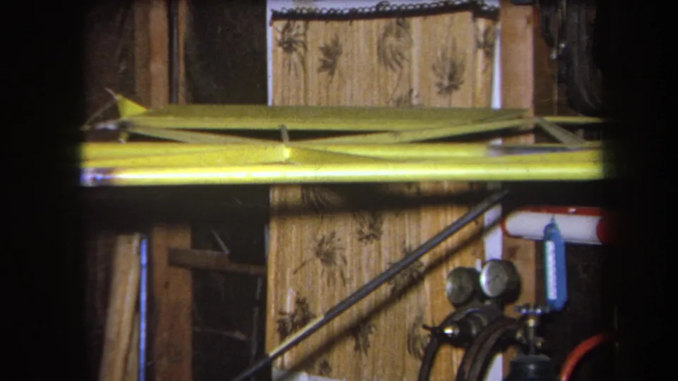 1964 Volmer Yucaipa frame with yellow-painted metal equipment, pressure gauges, hose connections, pipes, and patterned wall material.