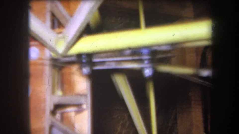 Final 1964 frame showing yellow-painted steel reinforcement crossing exposed wood framing and metal brackets.