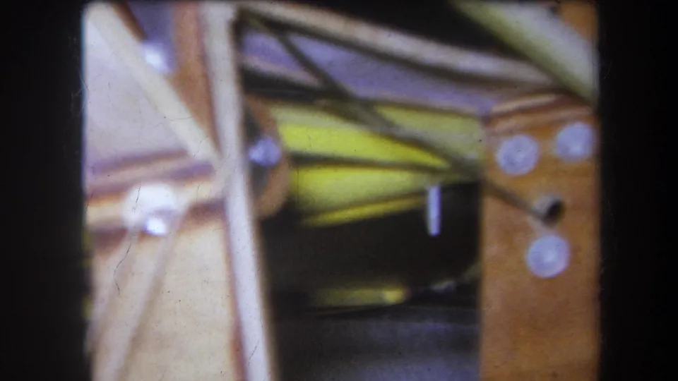 1964 Yucaipa 8mm frame with an angled pale support crossing a wood and metal machinery component.