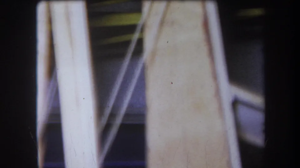 1964 Yucaipa close-up where a pale vertical support and diagonal metal brace obscure darker mechanical parts behind them.