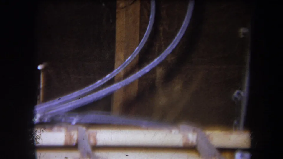 1964 Yucaipa home-movie frame showing curved tubing, wooden supports, and a pale rail on the homemade device.