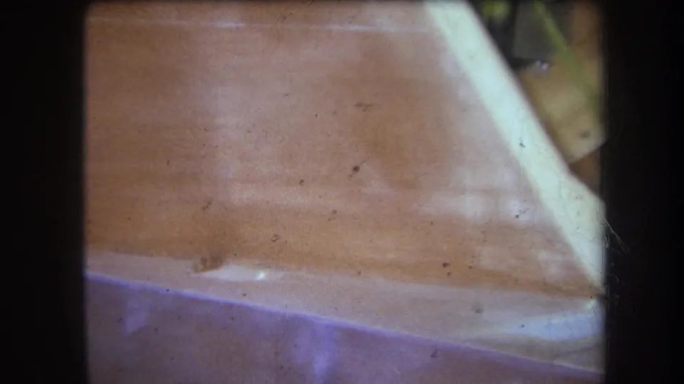 Late frame from the 1964 8mm clip showing the camera moved along the painted hull-like surface, leaving mostly texture and trim visible.