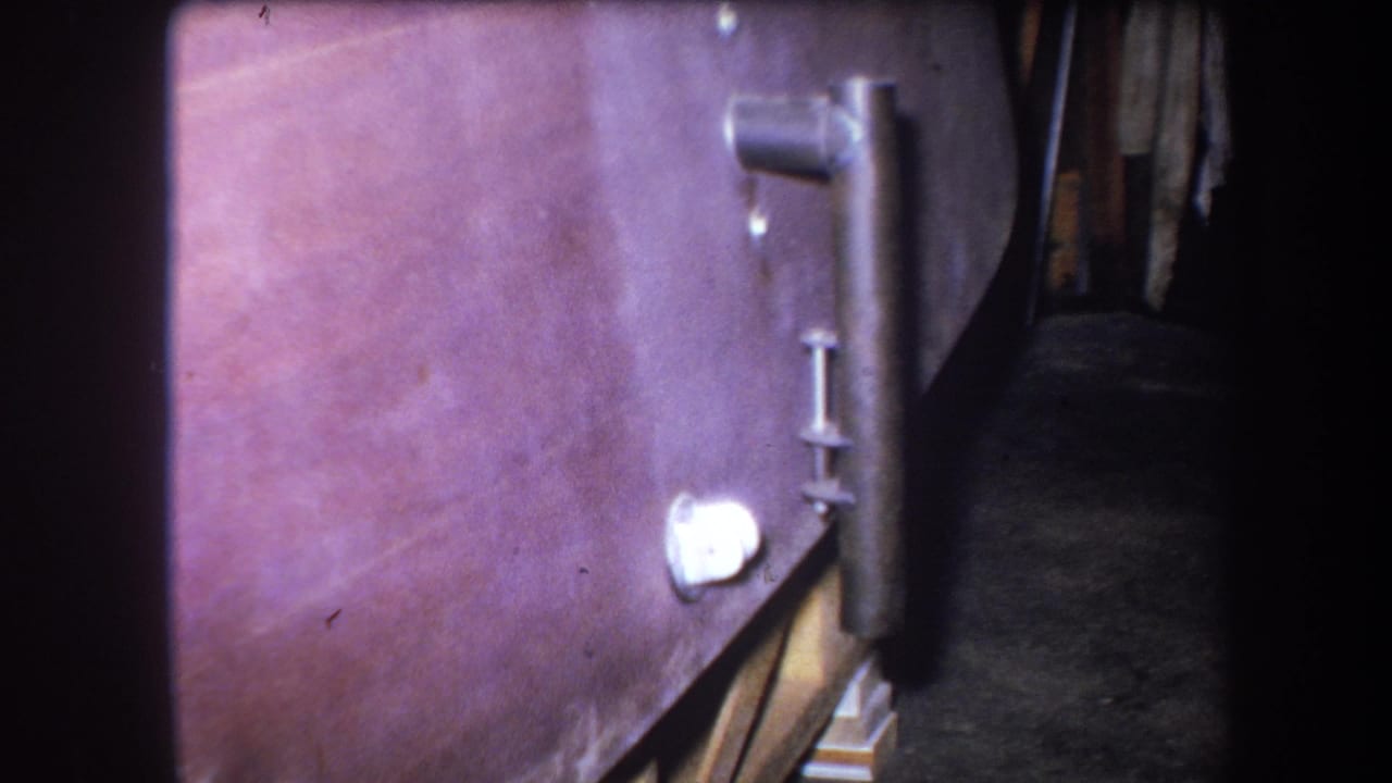 Boiler side with pipework, white fitting and dark space behind the equipment.
