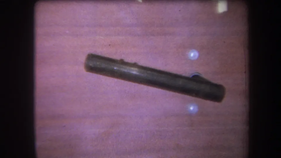 1964 Yucaipa interior detail with a dark rod or handle mounted across warm wood paneling and pale holes in the wall.