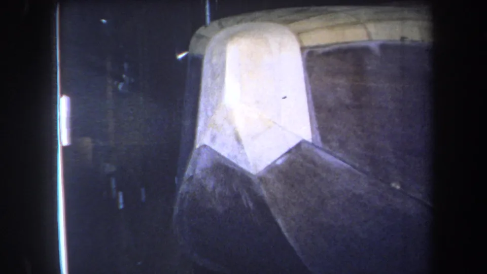 1964 Yucaipa-area home-movie frame with a close, soft-focus view of a pale bow-like panel and darker worn hull.