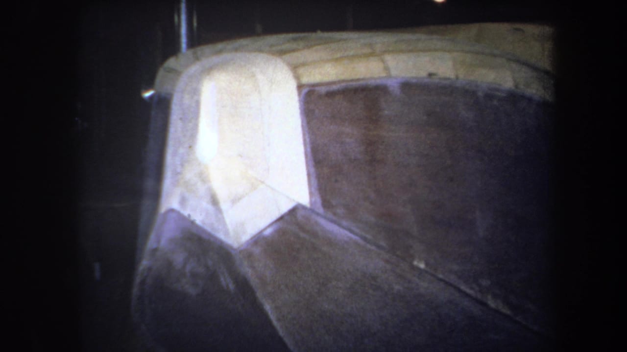 1964 Yucaipa 8mm frame showing a close view of an unidentified brown and white geometric structure with yellow edging.