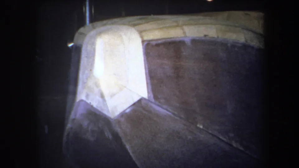1964 Yucaipa 8mm frame showing a close view of an unidentified brown and white geometric structure with yellow edging.
