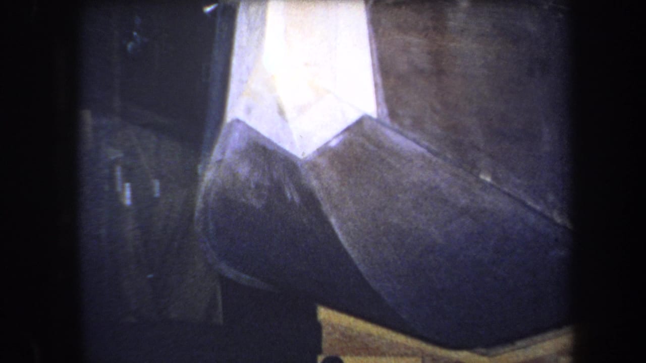 Close view of an angular painted metal sculpture with black, white, brown, and yellow sections.