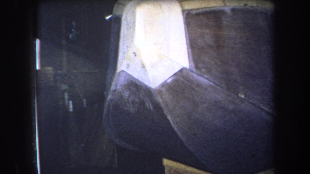 Close 1964 Yucaipa frame of the sculpture, emphasizing a bright white painted area over dark black and brown metal forms.
