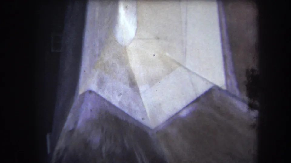 1964 Yucaipa close-up of a pale geometric plastic wall object, with dust, vignetting, and faded 8mm color.