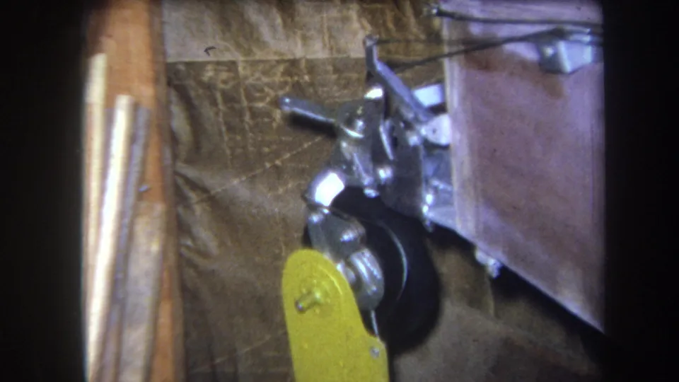 1964 Yucaipa 8mm frame showing the lever pulled lower beside a black wheel and compact metal mechanism.