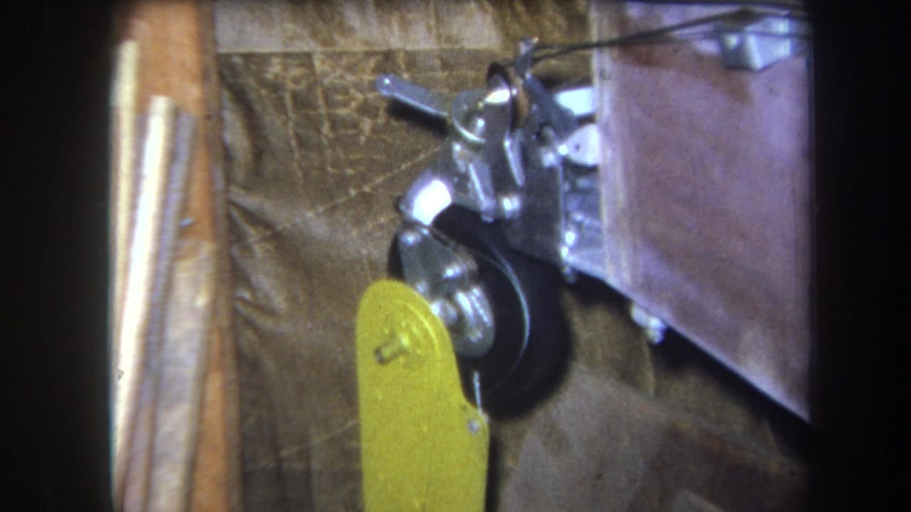 1964 Volmer, Yucaipa close-up with the yellow lever raised beside a black wheel and silver linkage in a rough work setting.