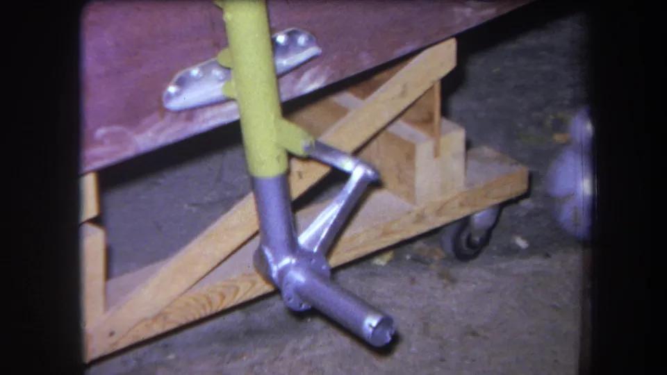 Close frame from the Yucaipa footage showing the handmade cart's metal brace and wooden wheeled support structure.
