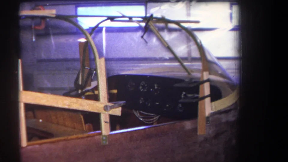 1964 Yucaipa 8mm frame showing the unfinished cockpit interior with canopy supports and exposed instrument wiring.