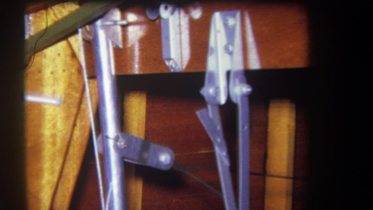 Similar close-up of metal hardware, rods, clamps, and wood surfaces.