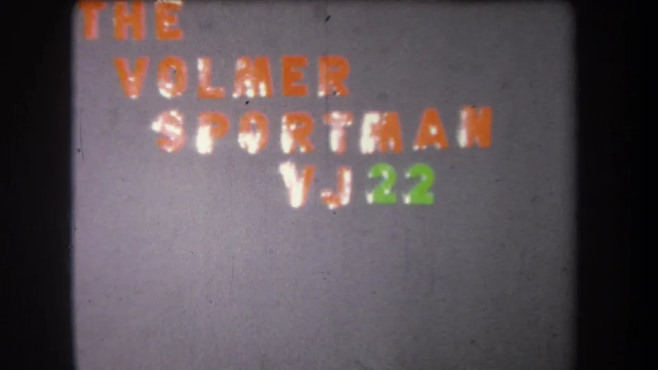 1965 8mm frame from the title sequence with The Volmer Sportsman and VJ22 arranged on a textured wall.