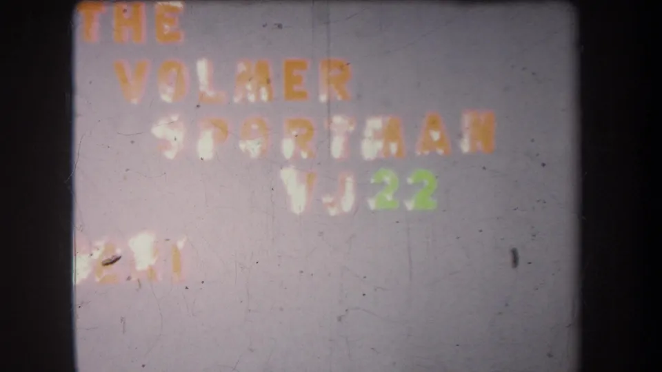 1965 8mm frame showing a faded exposure of The Volmer Sportsman and VJ22 title on a plain wall.