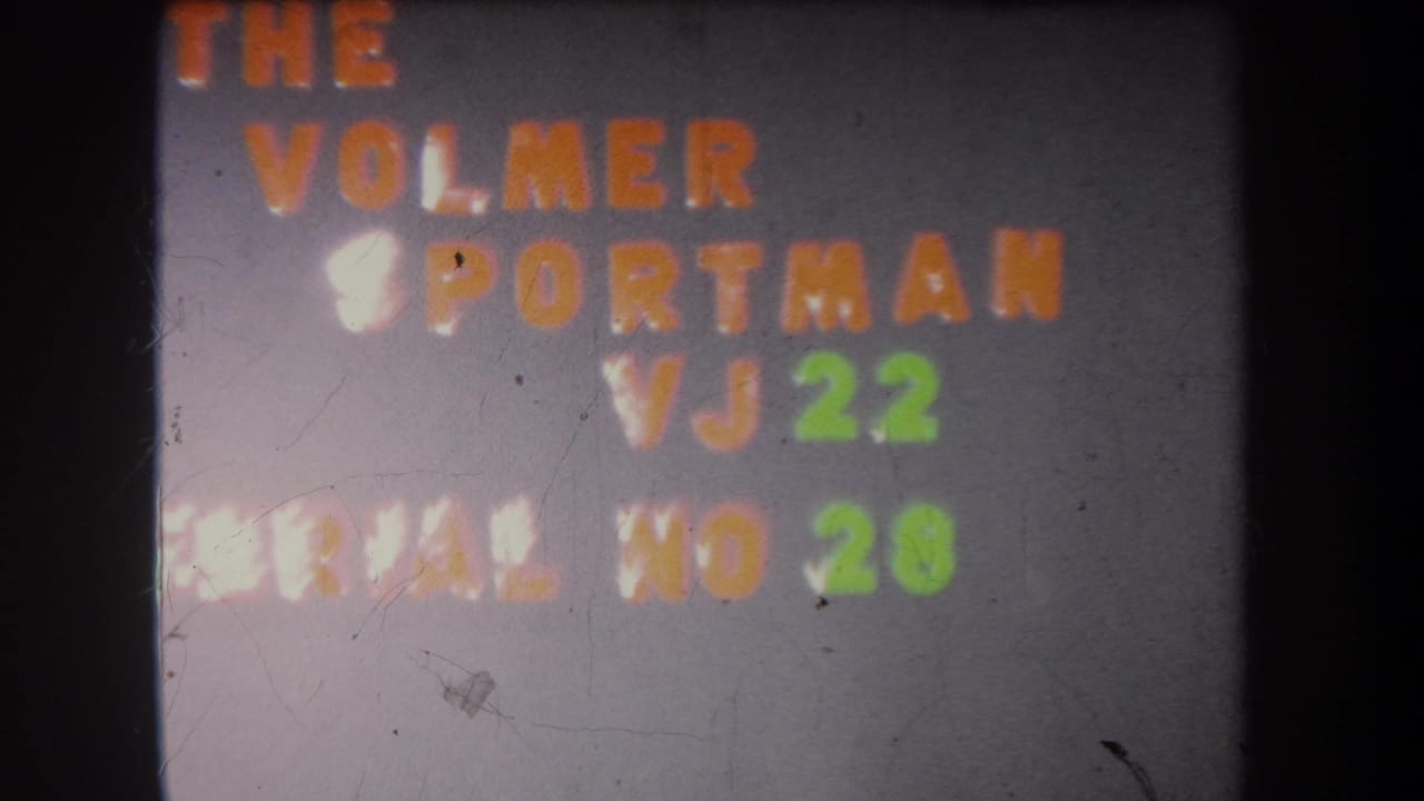 Clearer 8mm frame of the Volmer Sportman VJ 22 title card, including green serial number 28 on a gray board.