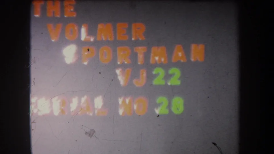 Clearer 8mm frame of the Volmer Sportman VJ 22 title card, including green serial number 28 on a gray board.