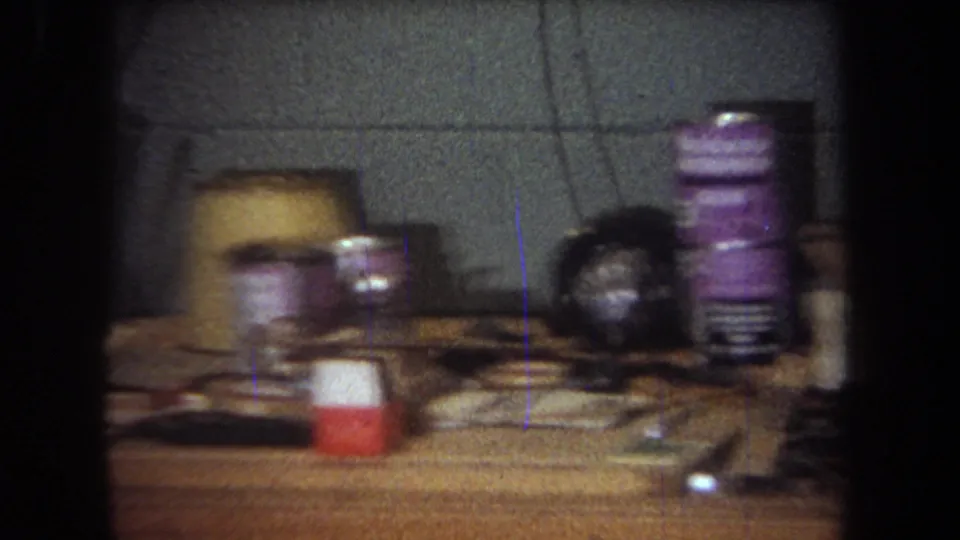 1965 Yucaipa-area home workshop view with cans, a small red-and-white container, cords, and hand tools on a table.