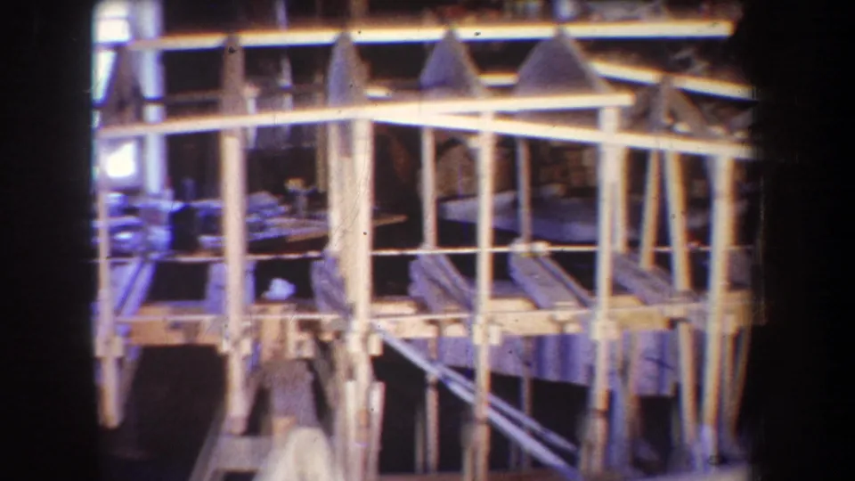 A closer 1965 Yucaipa view shows the wooden frame's posts, crosspieces, and angled supports inside the dim workshop.