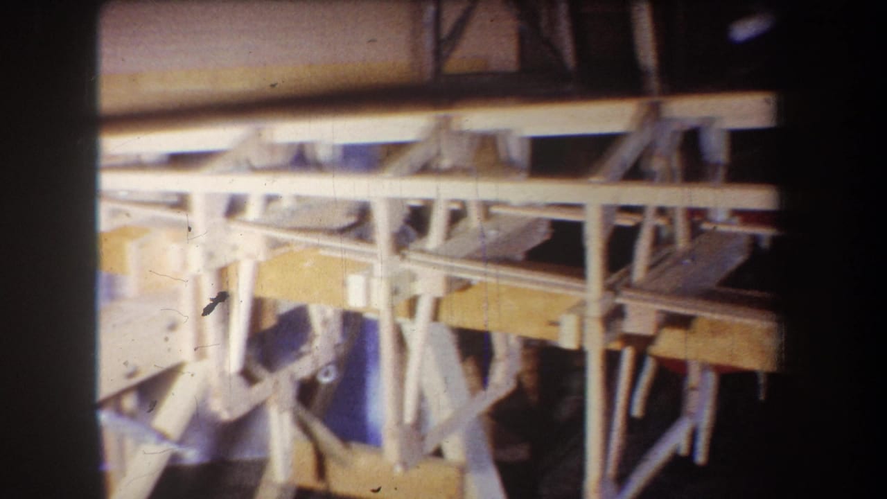 Boat frame details with pale beams, angled supports, and darker spaces behind them.