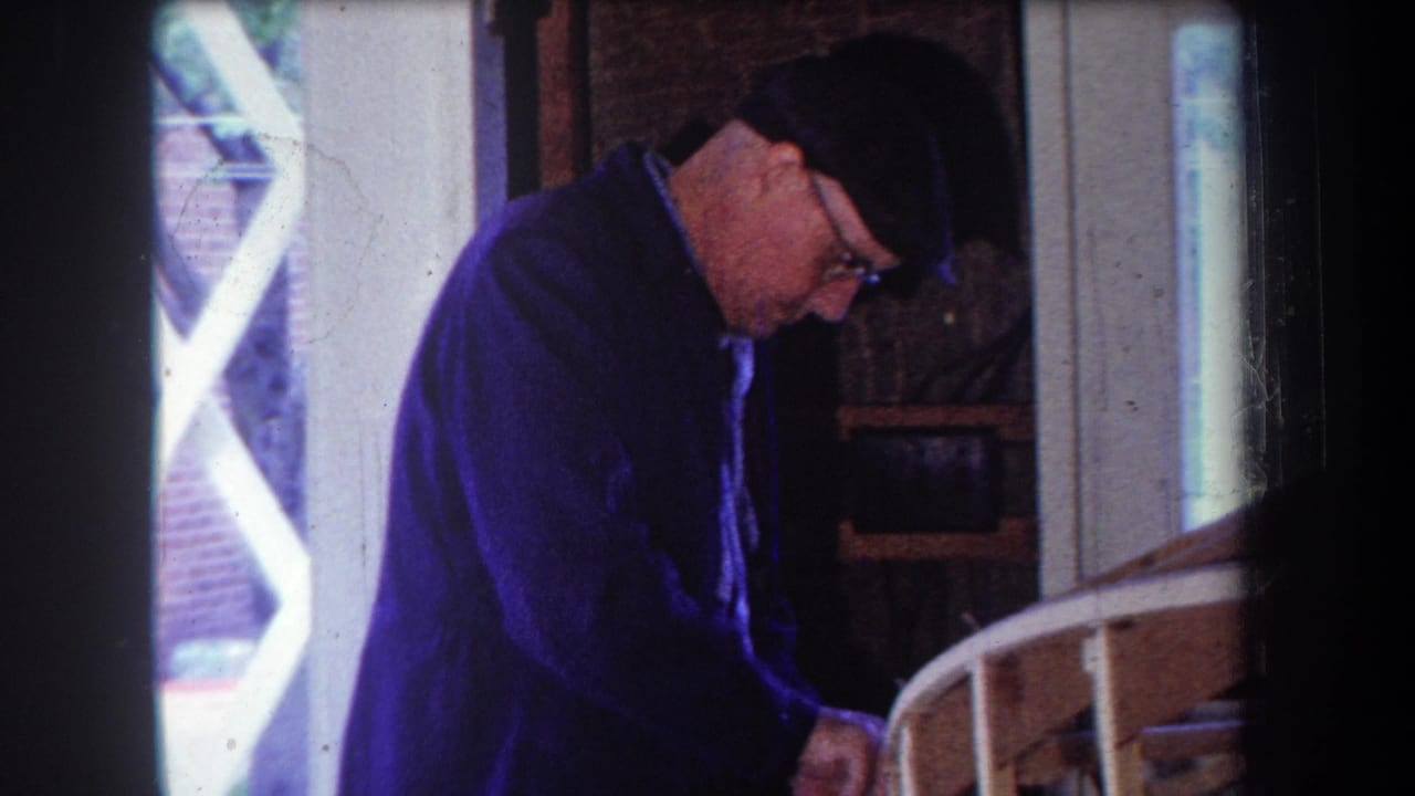 In 1965 Volmer Yucaipa home-movie footage, a man in a cap, glasses, and blue jacket works over wood pieces in a private workshop.