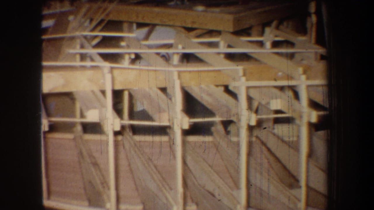 Wooden ceiling structure with rafters, braces, and open framing bays.
