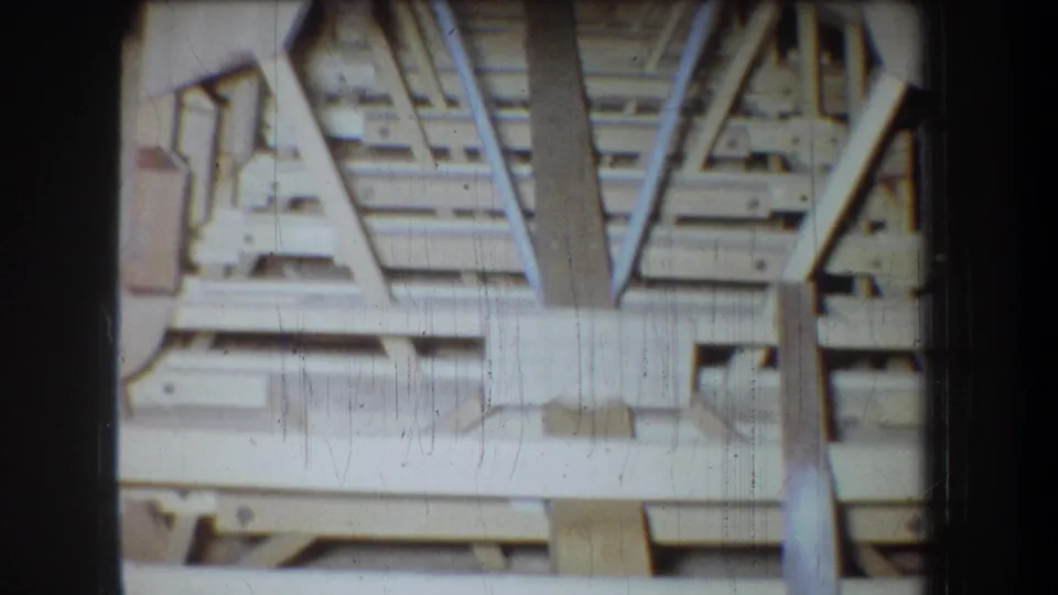 1965 Volmer Yucaipa attic view showing unfinished ceiling structure, beams, boards, and support members in soft 8mm color.