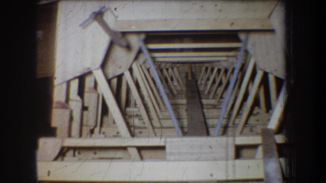 Wooden truss-like structure seen close up with diagonal supports.