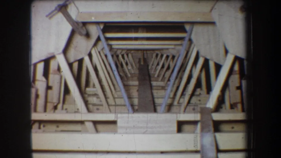 Final 1965 Yucaipa 8mm frame of a close wooden structure, showing rails, braces, and contact-sheet film borders.