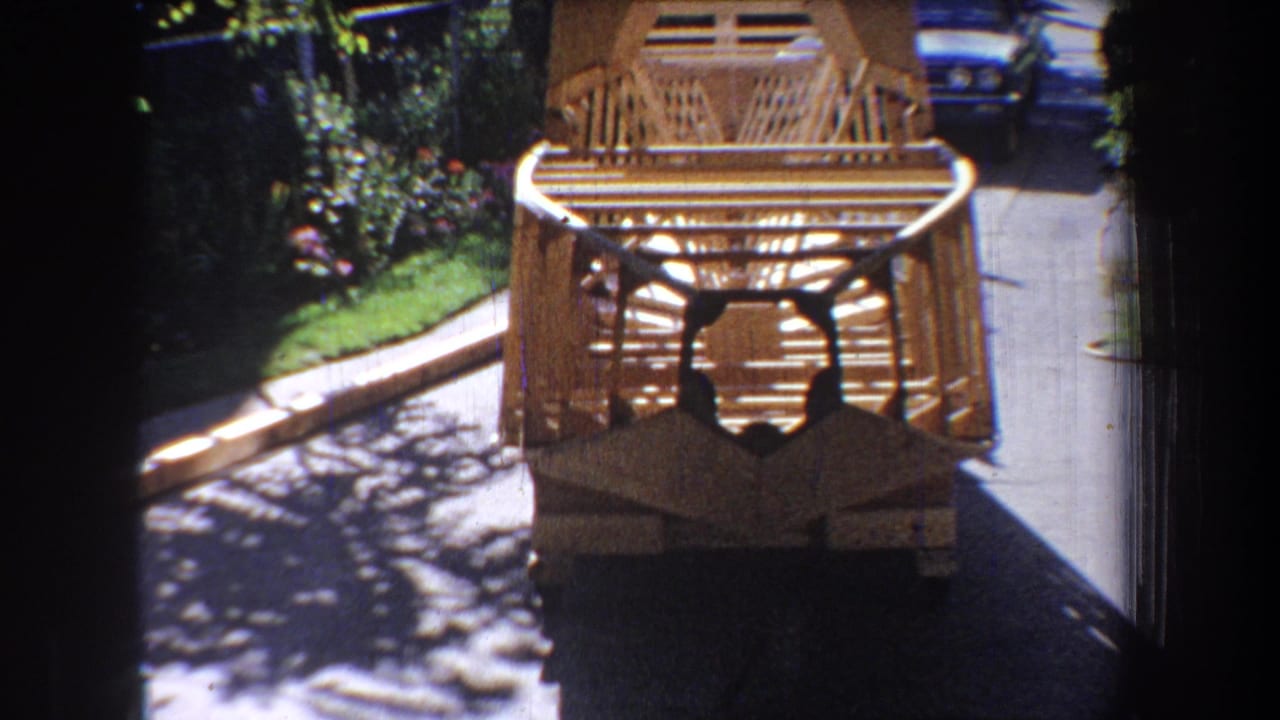 Wooden framework seen from below with pavement, plants, and a parked car behind.