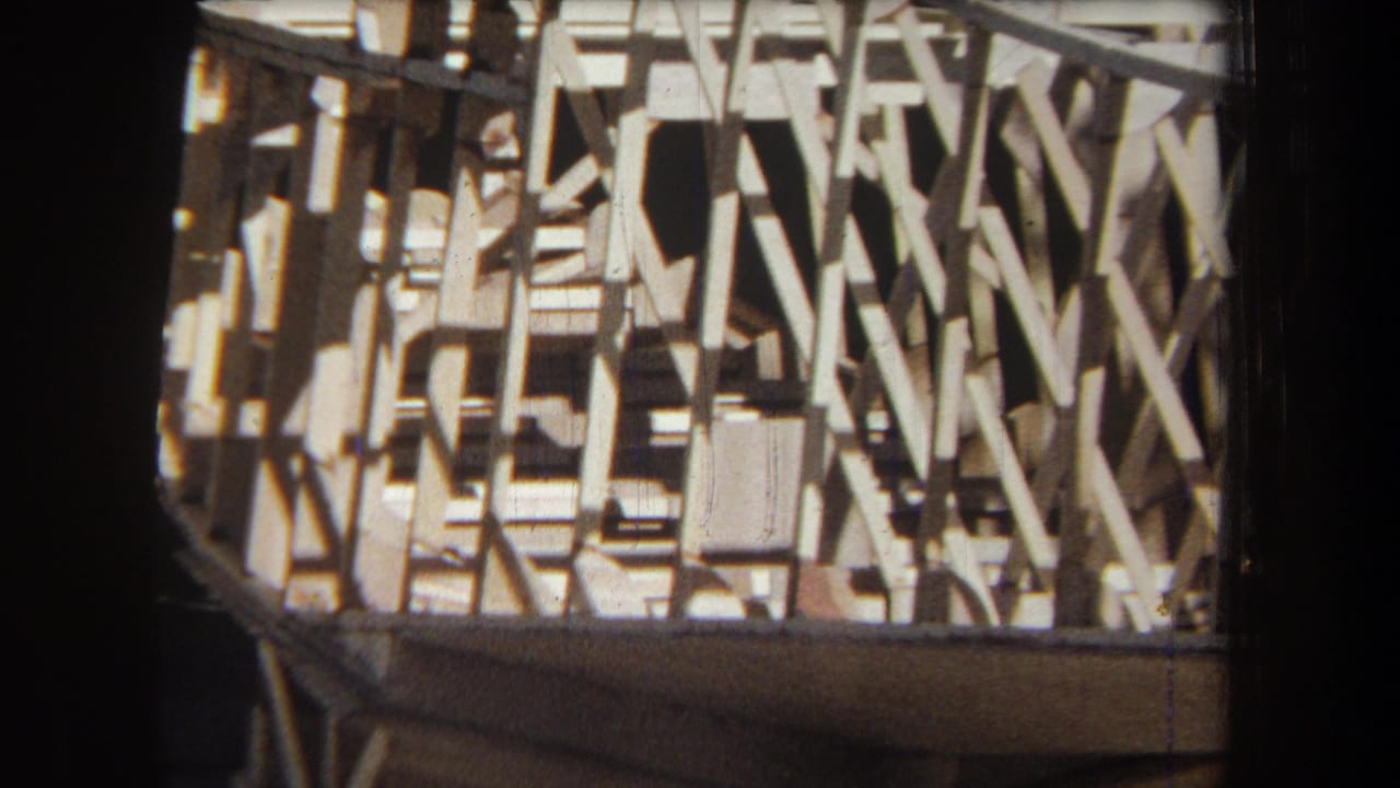 1965 Volmer Yucaipa 8mm frame showing exposed timber framing and lattice-like cross braces in bright sun.