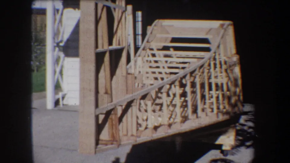 Unfinished wooden railing and deck framing appear beside a building in this 1965 Yucaipa-area home-movie frame.