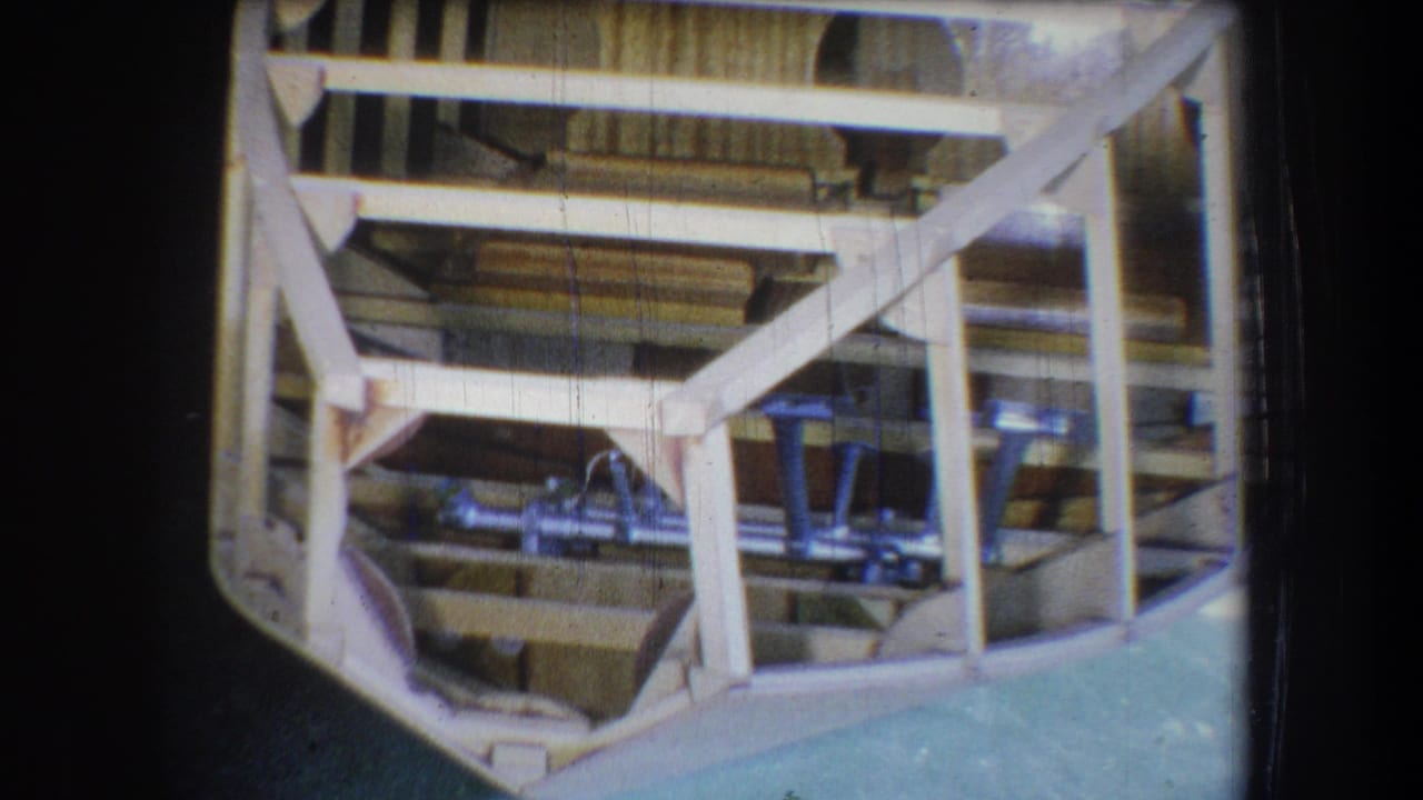 1965 Yucaipa-area 8mm frame showing exposed wooden boat ribs, beams, and two blue seats installed inside the hull.