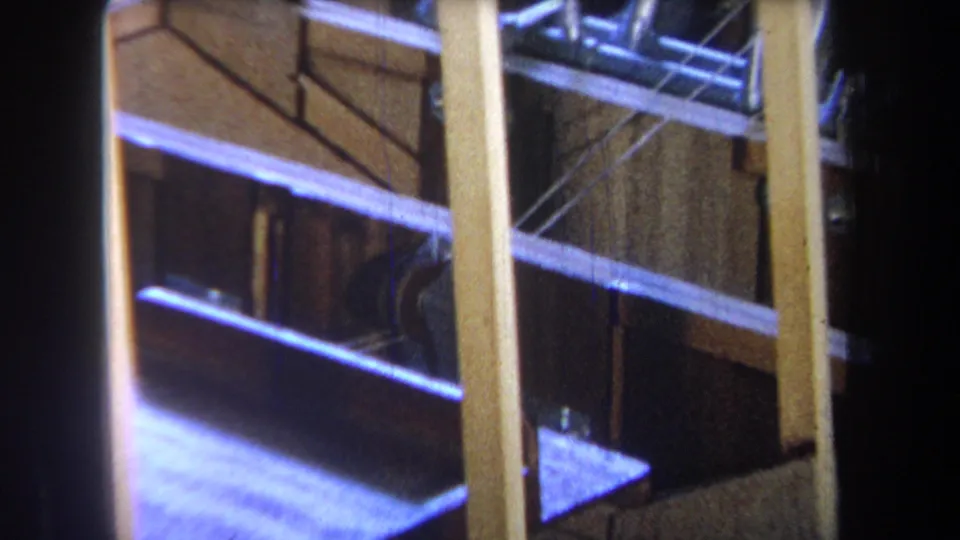 1965 Yucaipa-area 8mm frame showing exposed wooden studs, braces, and dark unfinished interior spaces.