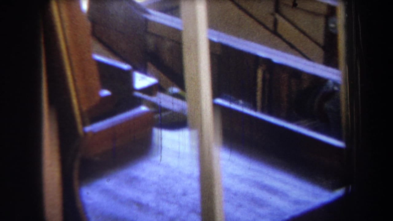 Angled view of wood framing beside a bright floor and dark opening.