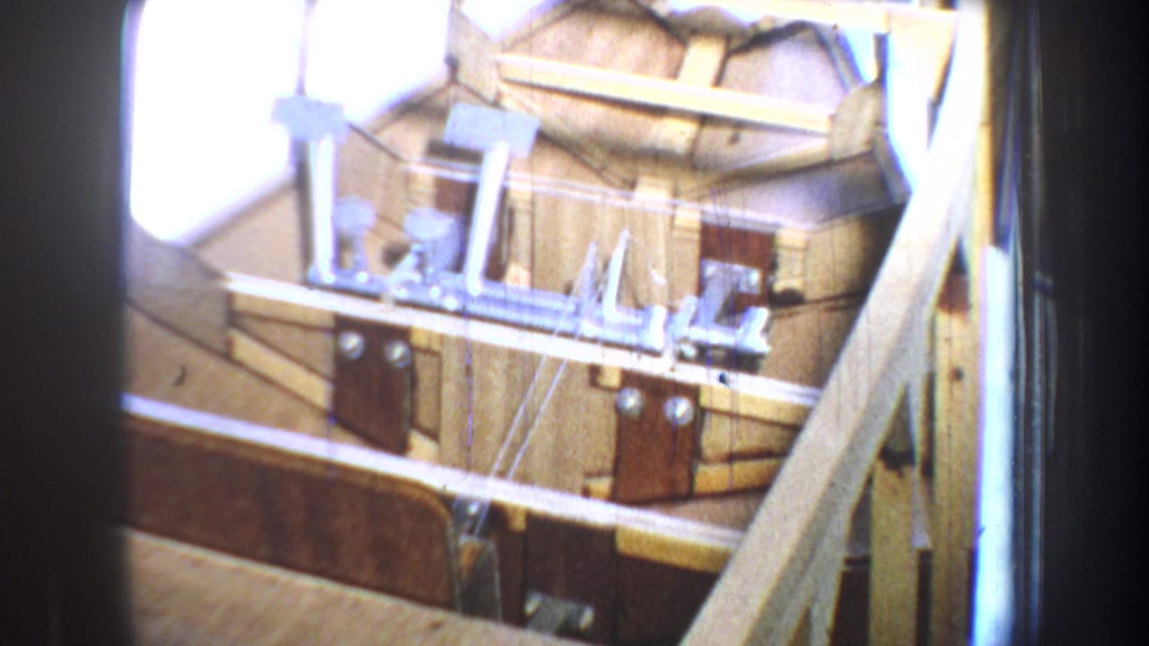 1965 Yucaipa home-movie view of exposed lumber, metal brackets, and unfinished construction details in daylight.