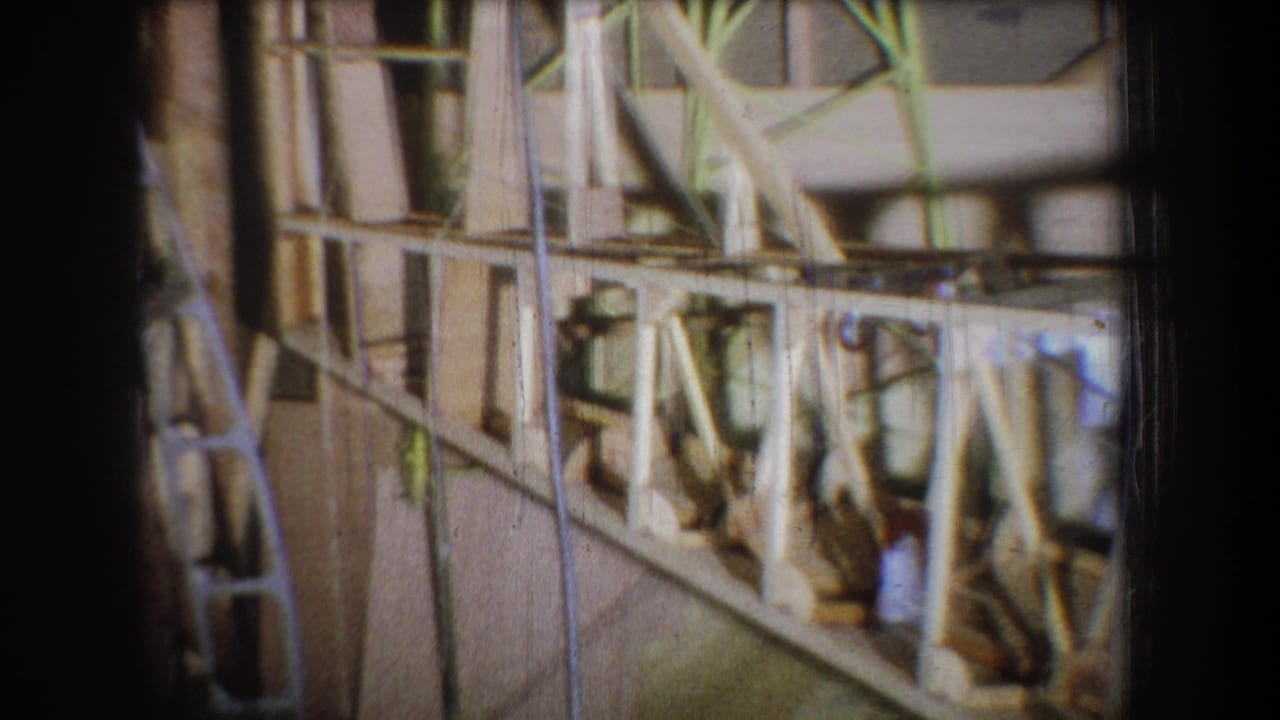 Wood framing and brace details seen through a soft, grainy 8mm frame.