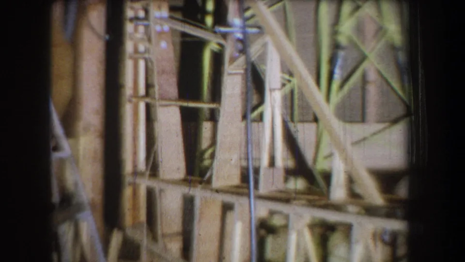 1965 Yucaipa-area 8mm frame showing a closer section of exposed lumber, vertical supports, and diagonal bracing inside construction.
