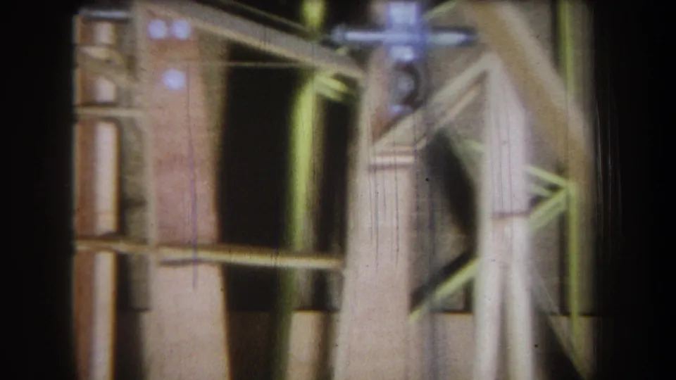 1965 Yucaipa-area 8mm close-up of an unfinished wall section with a dark opening, wood framing, and angled support members.
