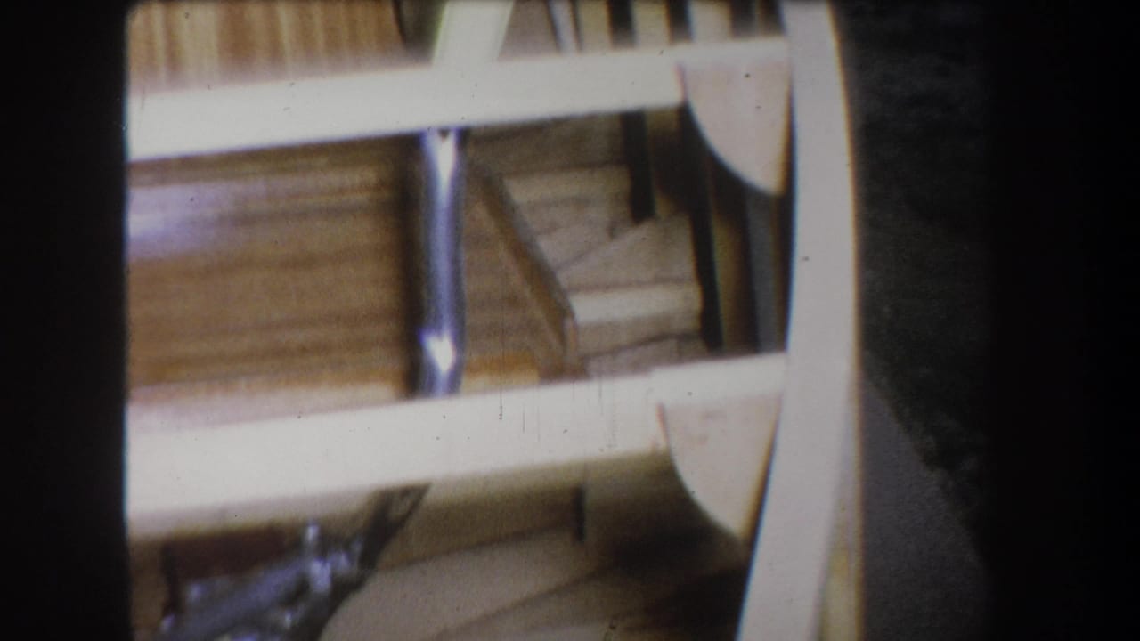 1965 8mm view from Yucaipa showing angled wooden boat framing, light-colored rails, curved ribs, and visible metal supports.